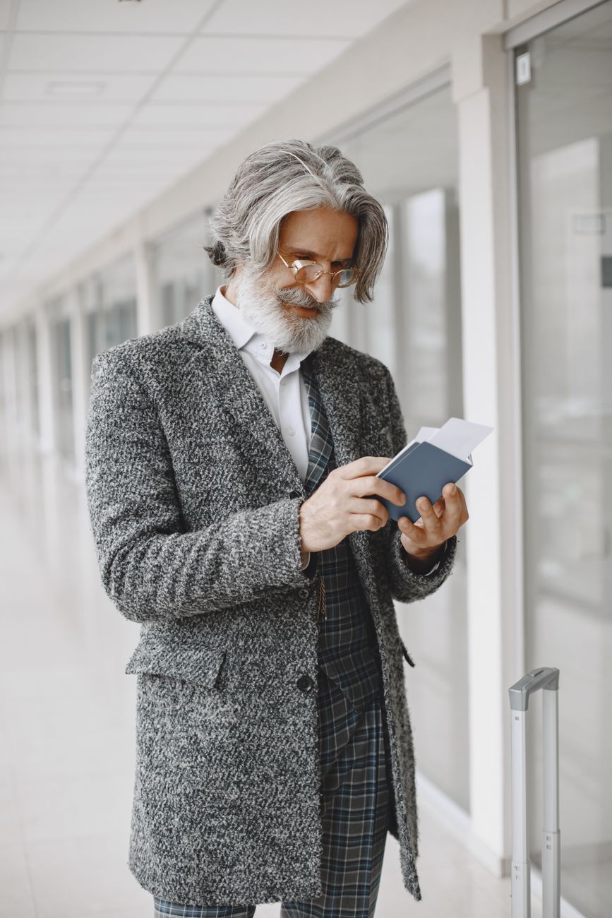 Smiling professional holding Canadian Passport with premium residential home backdrop